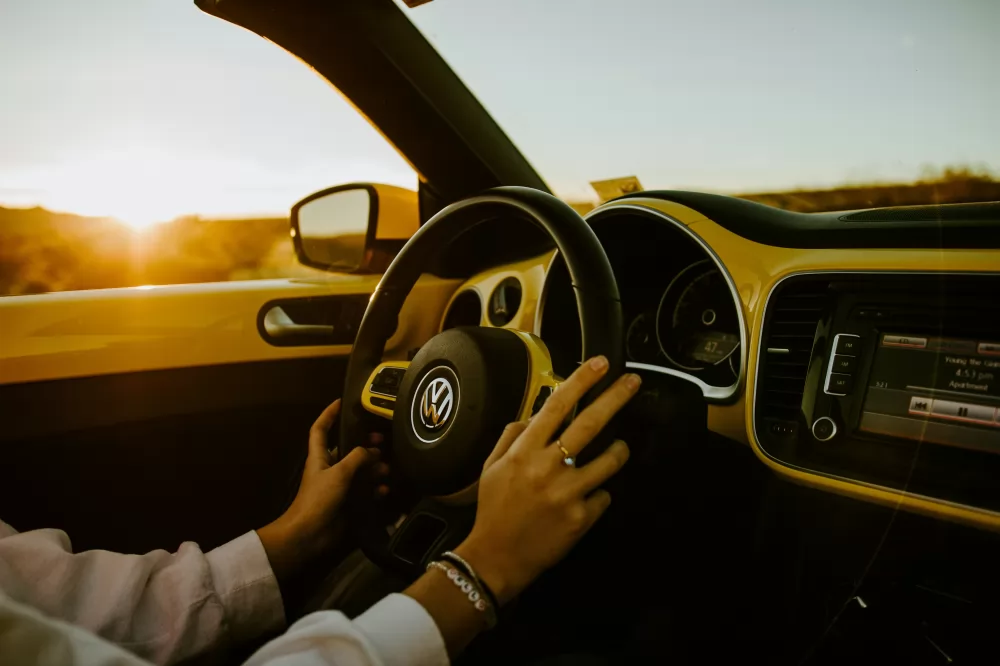 Händer på ratt körandes Volkswagen bil